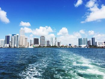 City skyline by sea against sky