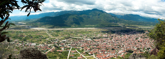 Scenic view of townscape and mountains against sky