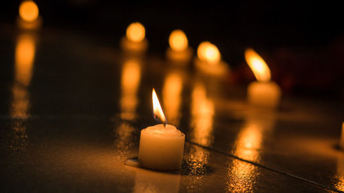 Close-up of illuminated candles on table