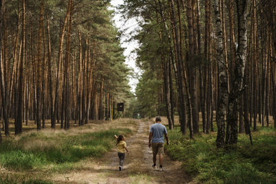 Girl with mature man hiking in forest