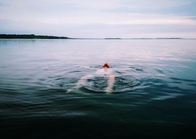 Portrait of person swimming in sea against sky