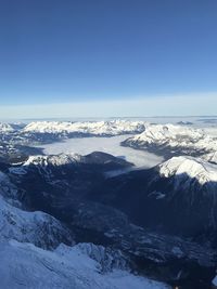 Scenic view of snowcapped mountains against blue sky