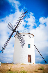 Whitewashed traditional windmill against sky