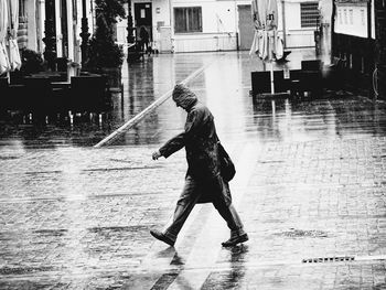 Man walking on street during rainfall