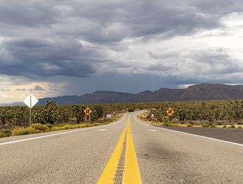 Surface level of empty road against cloudy sky