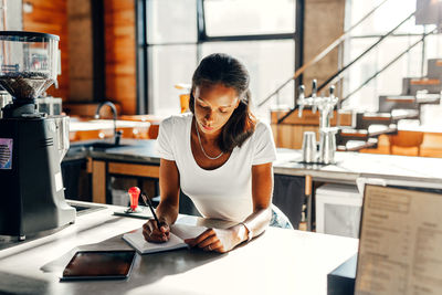 Woman using mobile phone while standing on table