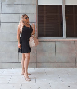 Full length of woman standing against tiled floor