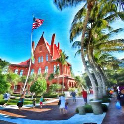 Palm trees and buildings against blue sky