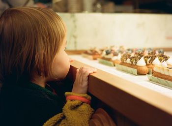 Little girl looking at pastries in a cafe