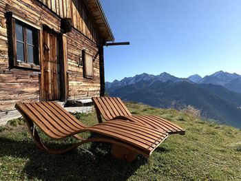 Empty chairs on field against buildings