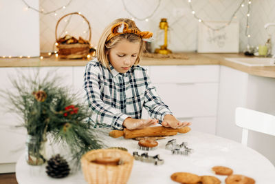 A cute girl in tiger ears is baking cookies for christmas or new year. symbol of the year