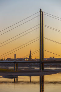 Bridge over river against sky during sunset