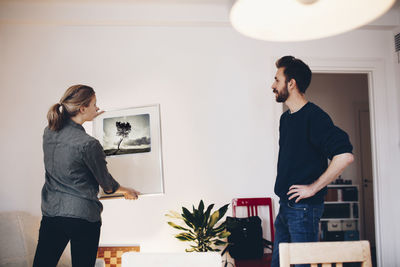 Man and woman discussing painting at home