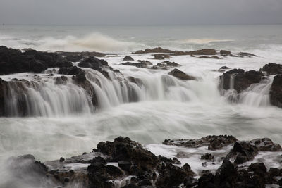 Scenic view of waterfall against sky