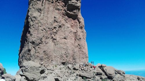 Low angle view of rock formation against clear blue sky