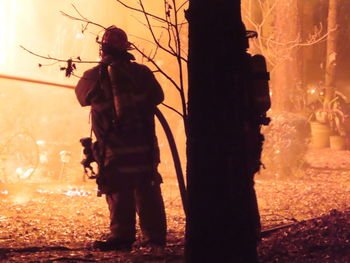 Rear view of men standing by building at night