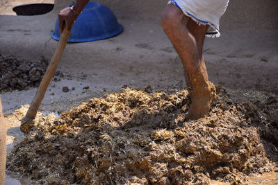 Low section of man working on mud