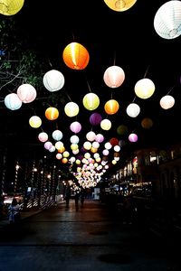 Illuminated lanterns hanging on street at night