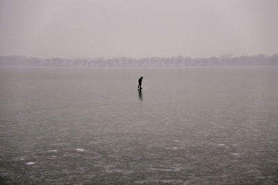 Silhouette person on snow covered field