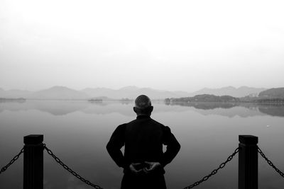 Man standing on cliff by sea