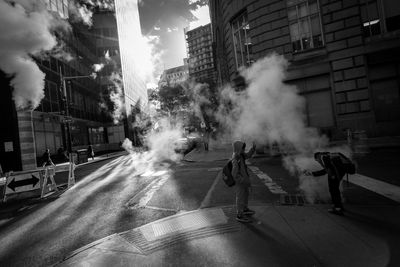 People walking on street amidst buildings in city