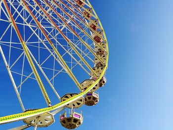 Low angle view of ferris wheel against blue sky