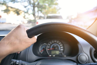 Cropped hand of man driving car