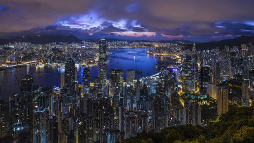 Illuminated cityscape against sky at night