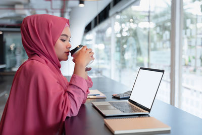 Side view of woman using mobile phone