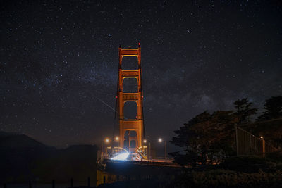 Illuminated golden gate bridge under beautiful star field at night