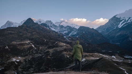 Rear view of woman with snowcapped mountains against sky