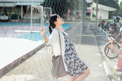 Young woman leaning on net in court