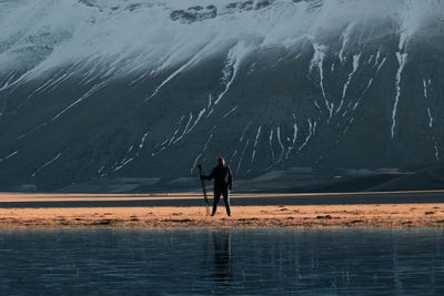 Rear view of man standing in water