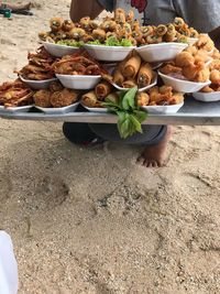 Low section of man holding various food in tray