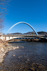 Bridge over river against blue sky