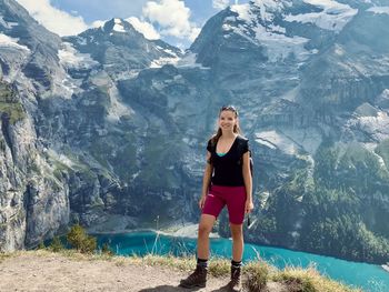 Full length of young woman standing against mountain