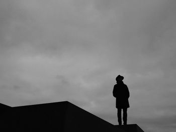 Low angle view of silhouette man standing against sky at dusk