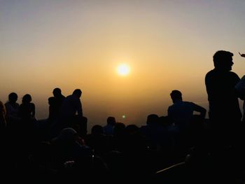 Silhouette people against sky during sunset