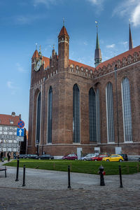 People in front of historical building against sky