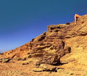 Low angle view of rock against clear blue sky