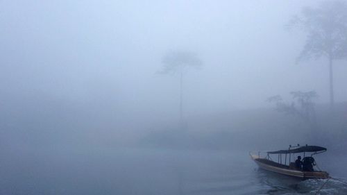 Boat sailing in river during foggy weather