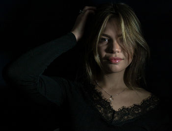 Portrait of beautiful woman against black background