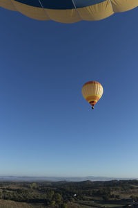 Low angle view of hot air balloon against clear blue sky