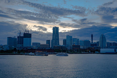 Modern buildings in city against sky during sunset