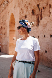 Young woman standing against wall