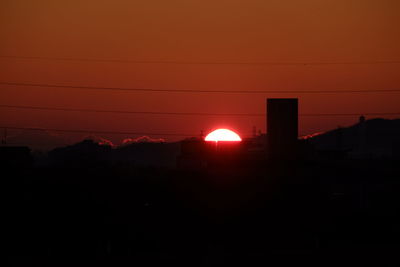 Silhouette built structure at sunset