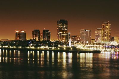 Illuminated cityscape against sky at night