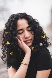 Close-up of young woman wearing yellow flowers