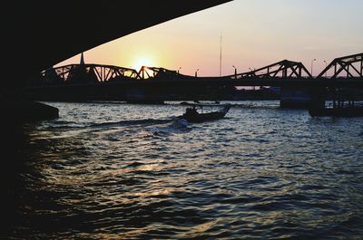 Silhouette of suspension bridge over river