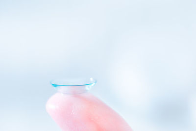 Close-up of hand holding wineglass against white background
